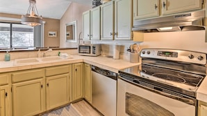 A kitchen with light green cabinets, a stainless steel range, a microwave, and a dishwasher. - 3BR Riverfront Retreat 1 Min to Vail or BC Shuttle (Avon)