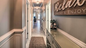 A hallway with a wooden sign that reads "Relax" and "Wind & Enjoy." - Ocean Club Condo w/ Community Pool & Hot Tub (Atlantic Beach)
