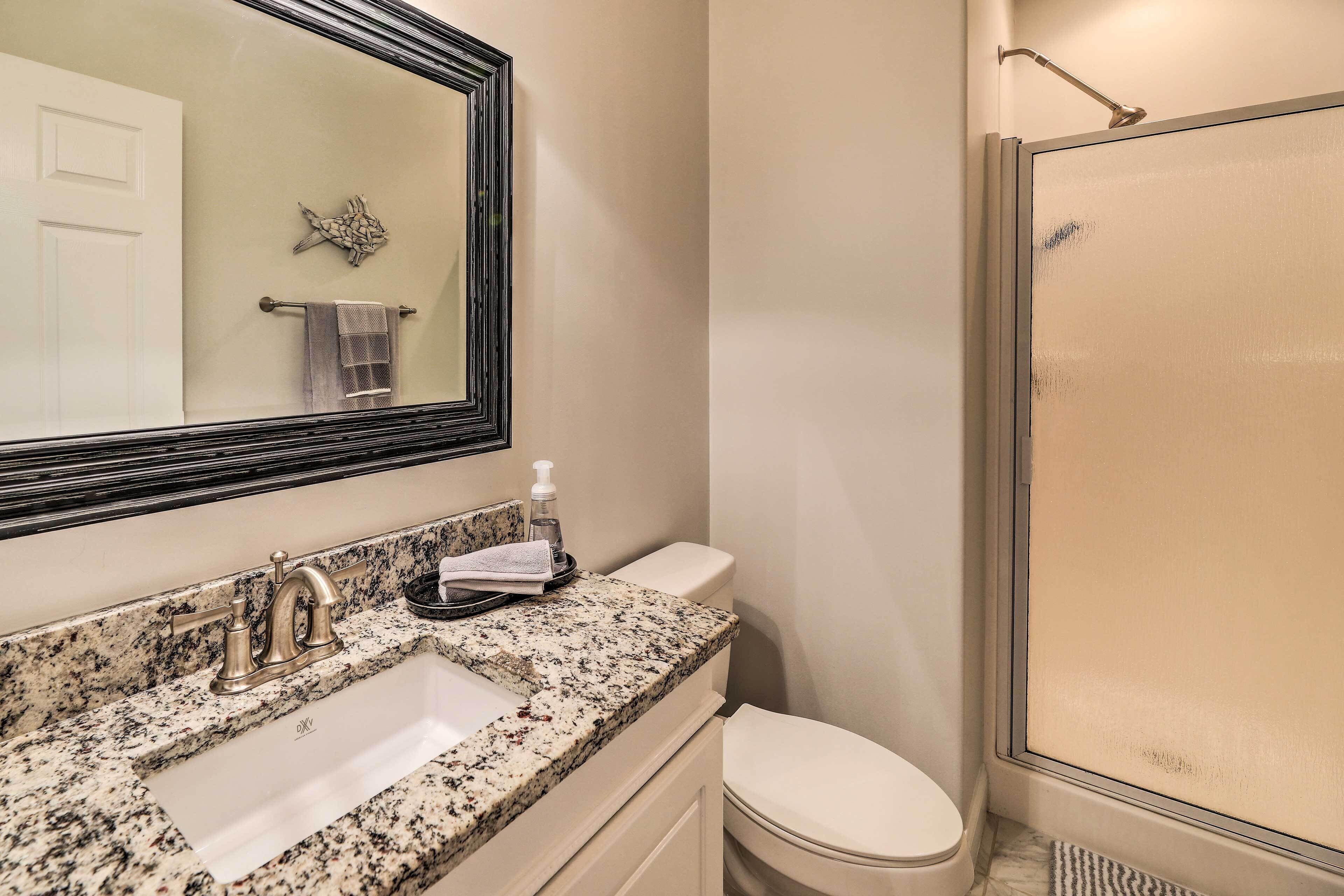 Un bagno con lavabo in granito, un water e un box doccia.