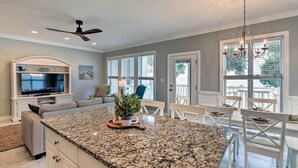 A kitchen with granite countertops, a built-in TV, and a ceiling fan. - Ocean Club Condo w/ Community Pool & Hot Tub (Atlantic Beach)