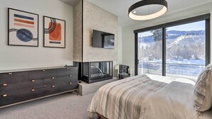 A modern bedroom with a fireplace, large windows, and artwork on the wall. - Luxe Park City Townhome w/ Hot Tub: 1/2 Mi to Lift (Park City)