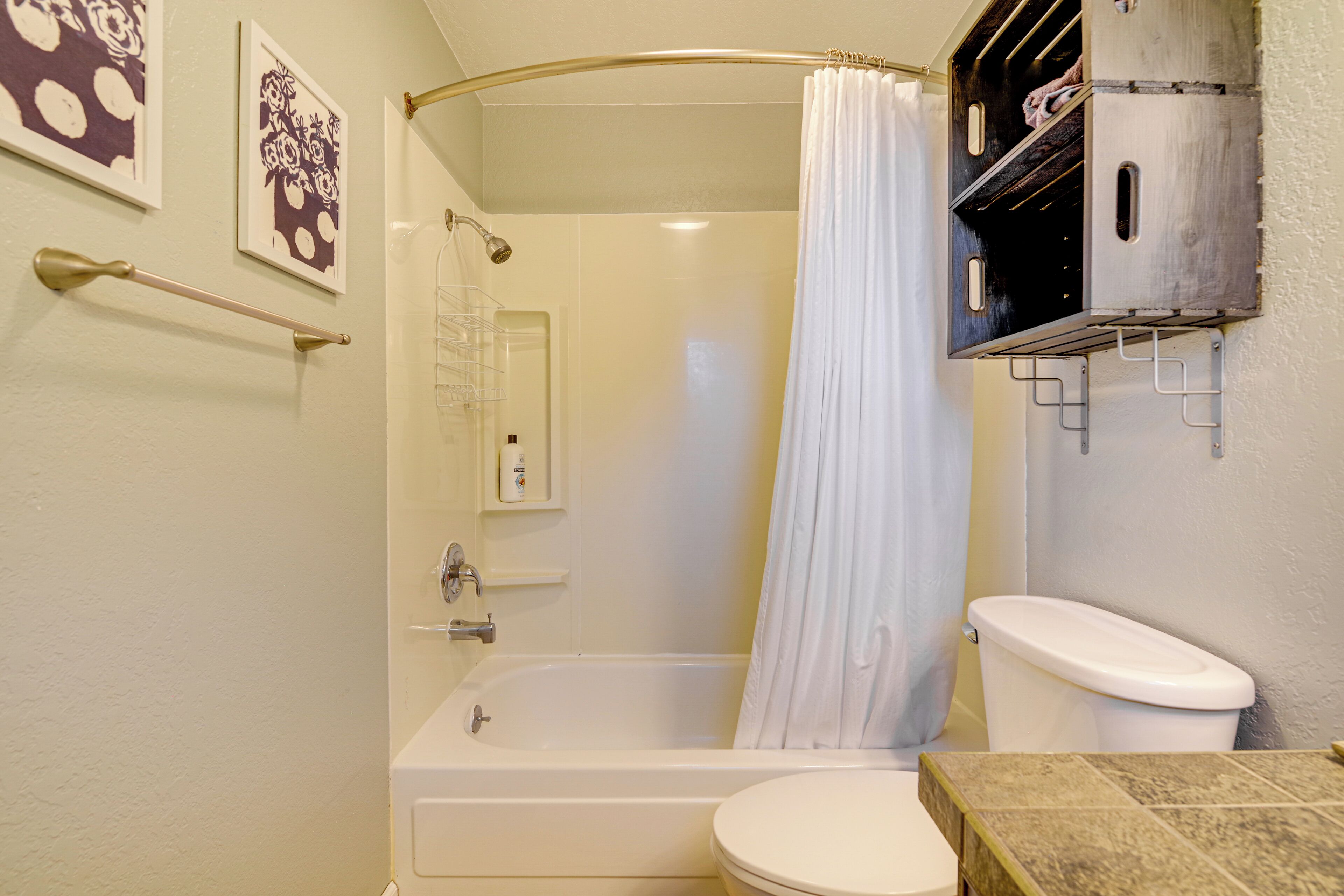 Une salle de bain avec une baignoire, des toilettes et un rideau de douche.