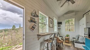 A rustic cabin interior with a wooden interior, large windows, a bar area, and a cozy seating space.