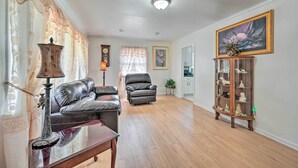 Un salon avec un canapé en cuir, un meuble en bois doté de portes en verre et un tableau accroché au mur.