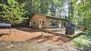 A cabin with a deck, surrounded by trees. - Rustic Mcgregor Retreat on Big Sandy Lake! (McGregor)