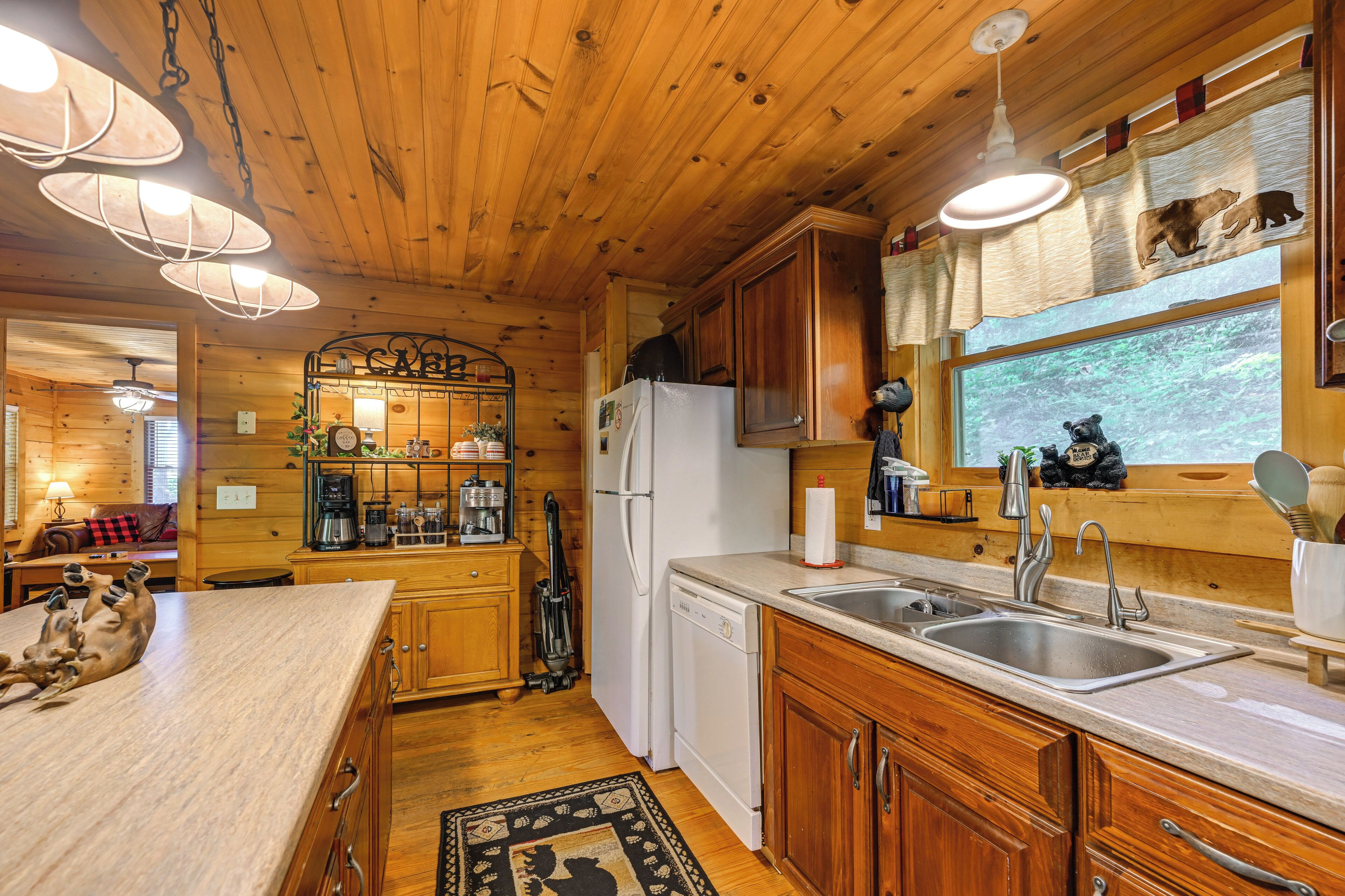 A wooden cabin kitchen with a refrigerator, dishwasher, and wooden cabinets.