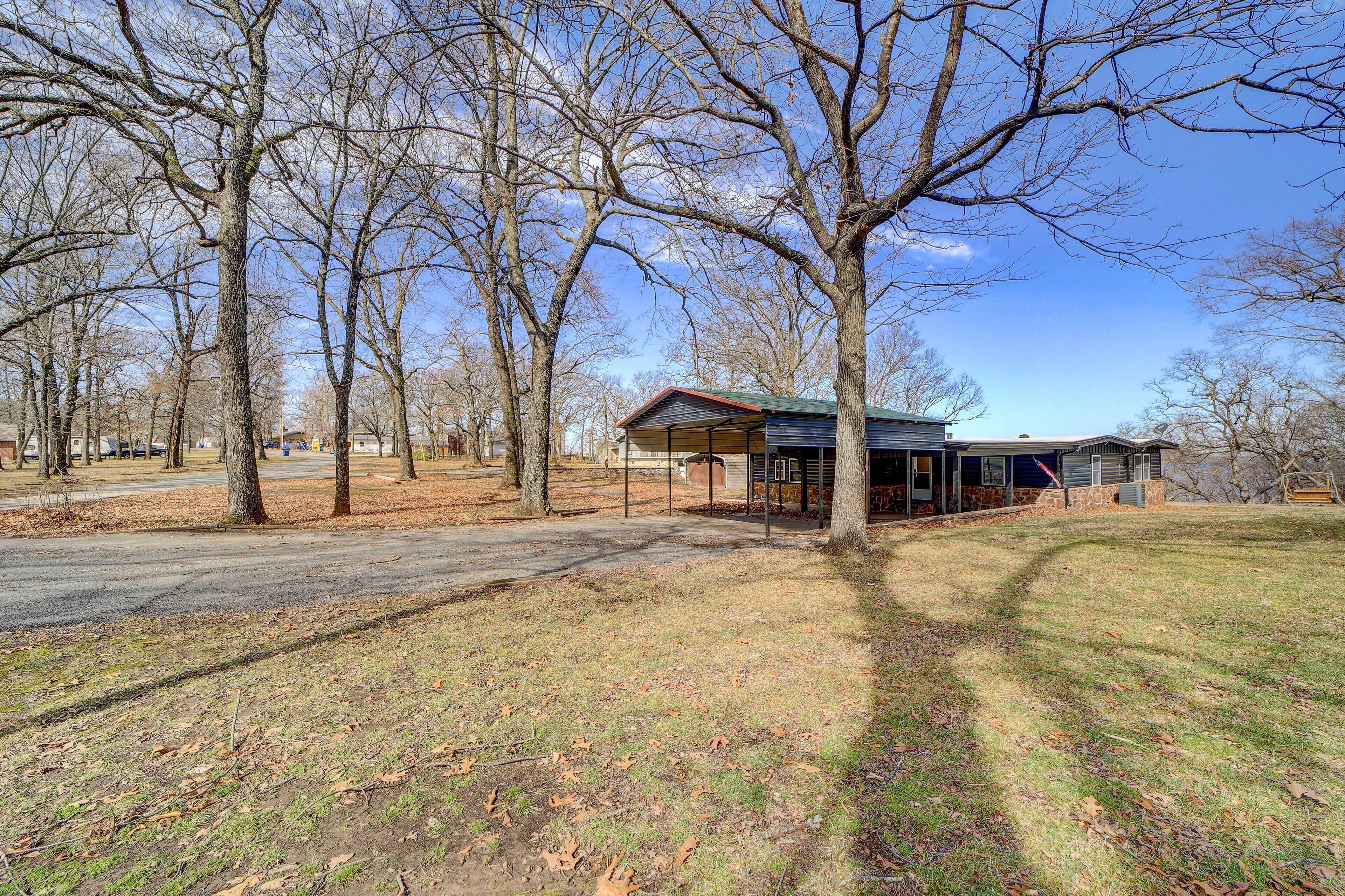 A house with a covered porch, surrounded by leafless trees and a clear sky.