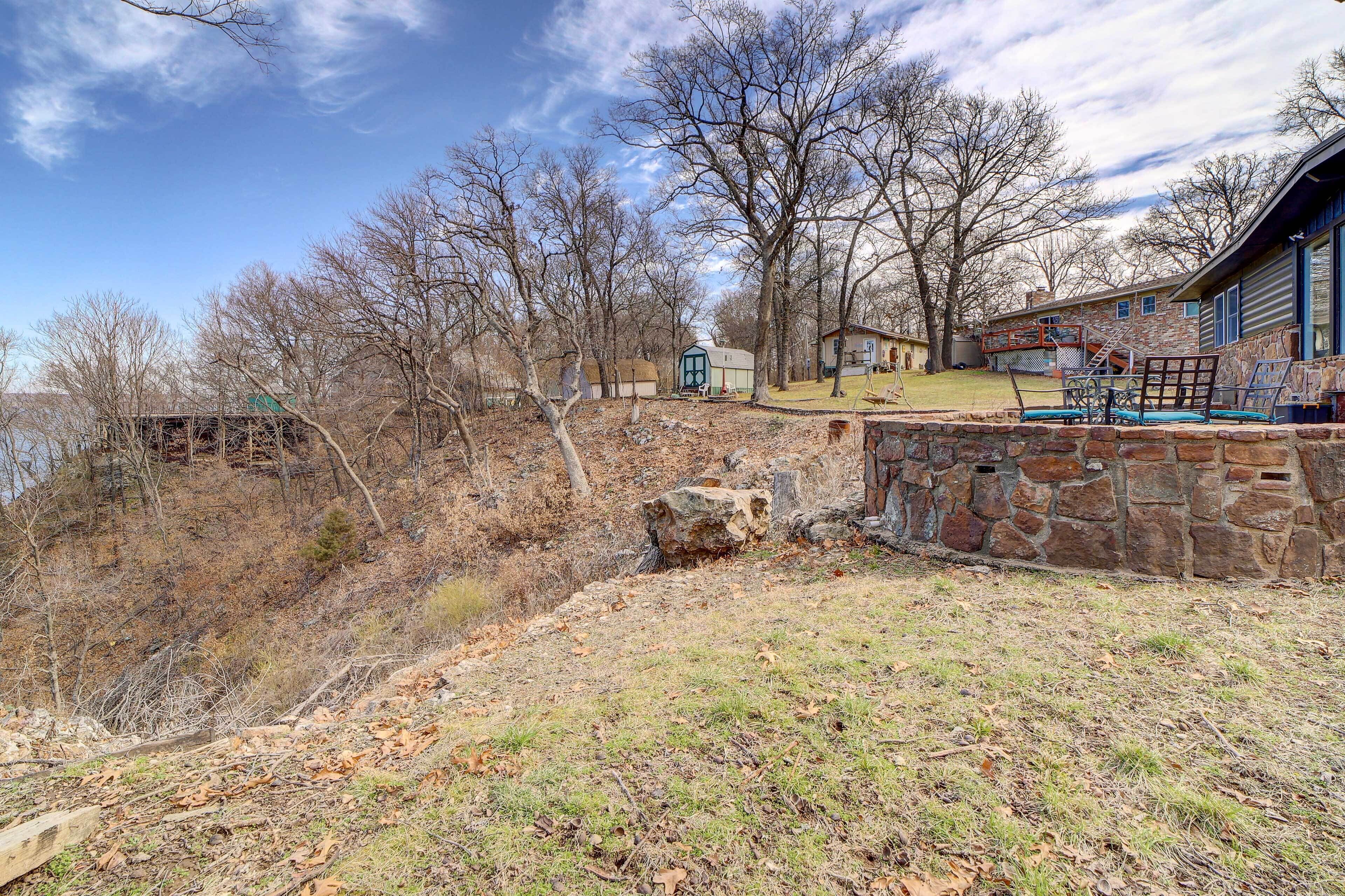 A stone wall, a wooden deck, and a house with a stone exterior.
