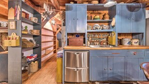 A rustic kitchen with wooden cabinets, a stainless steel refrigerator, and various kitchen utensils and cookware. - 10 Mi to Hot Springs Natl Park: Home w/ Grill! (Hot Springs)