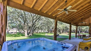 A hot tub under a wooden pergola with a view of a grassy yard and trees. - Riverfront Blanco Home w/ Shaded Porch + Hot Tub (Blanco)