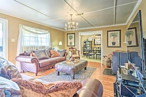 A spacious living room with leather sofas, a chandelier, and a dining area with chairs and a table. - Oxford Home on Private Land < 7 Mi to Dtwn! (Oxford)
