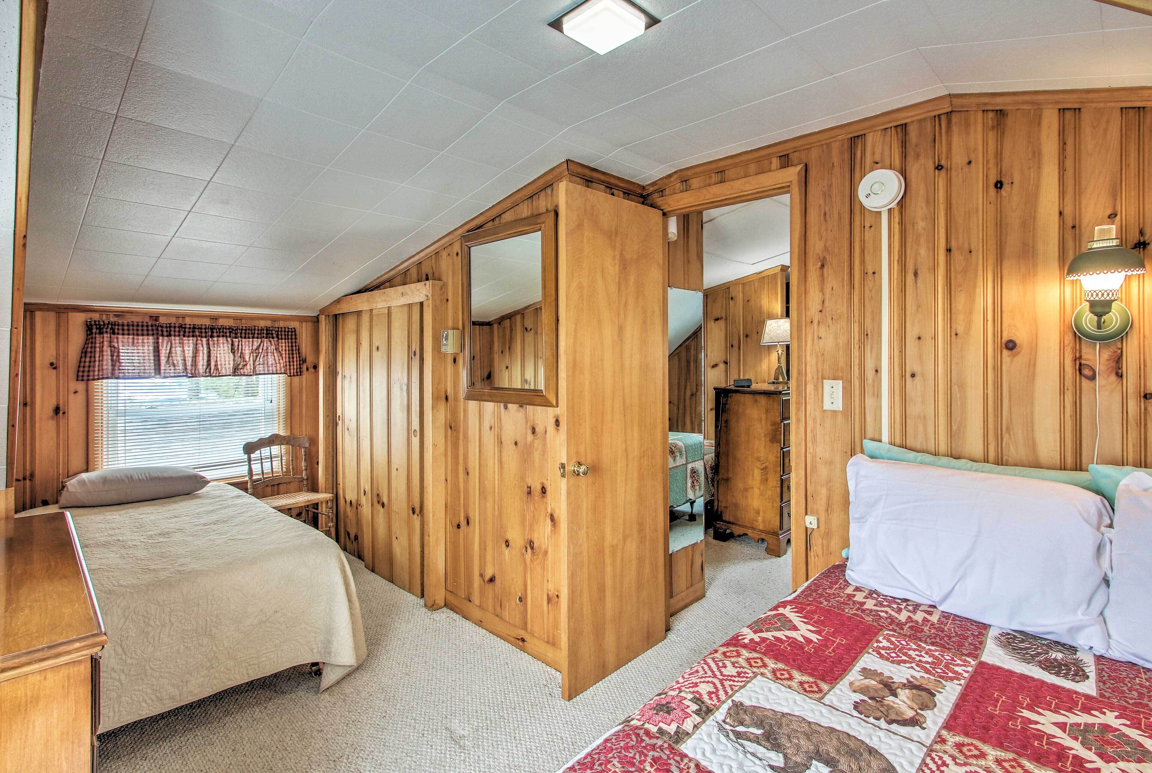 Um quarto com cama, escrivaninha, cadeira e guarda-roupa.