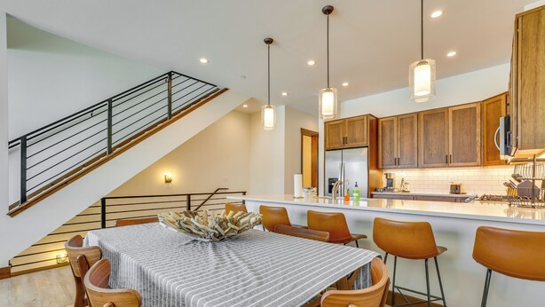 A modern kitchen with wooden cabinets, a central island, and pendant lighting. - Modern Fraser Townhome w/ Private Hot Tub & Decks! (Fraser)