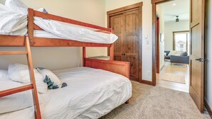 A bunk bed with white bedding and a wooden headboard in a room with beige carpet. - Modern Fraser Townhome w/ Private Hot Tub & Decks! (Fraser)