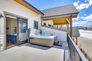 Egy jakuzzi a balkonon, ahonnan hóborította hegycsúcsokra nyílik kilátás.