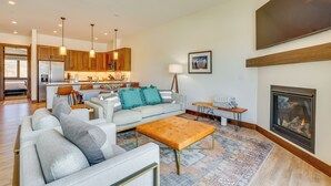 A modern living room with a sofa, ottoman, and a fireplace. - Modern Fraser Townhome w/ Private Hot Tub & Decks! (Fraser)