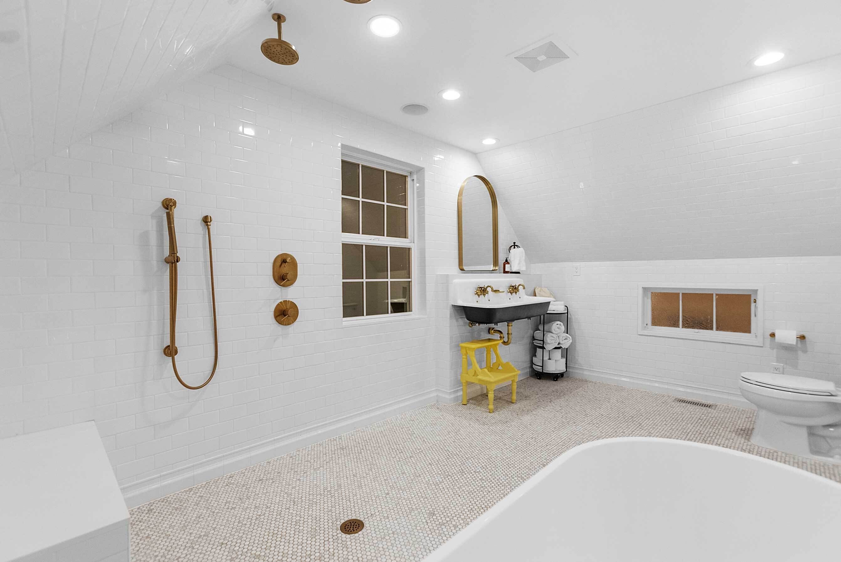 Un baño amplio con una bañera grande, zona de ducha separada y ventana que proporciona luz natural.