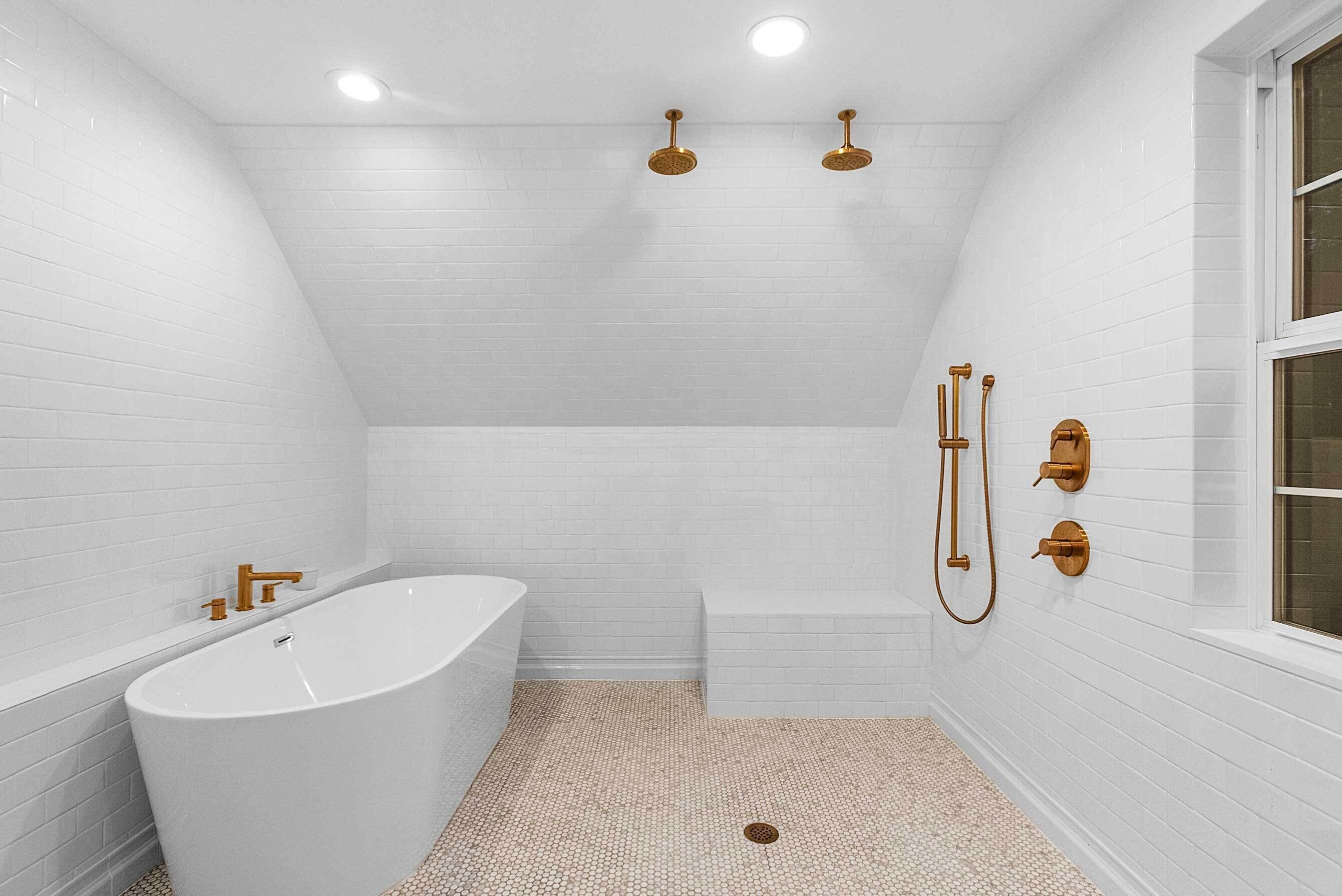 A modern bathroom with a freestanding bathtub, a shower area, and a window.