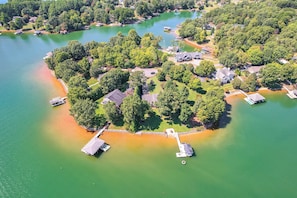 An aerial view of a lakeside property with multiple houses, docks, and boats. - Couples Smith Mtn Lake Getaway w/ Private Beach (Huddleston)