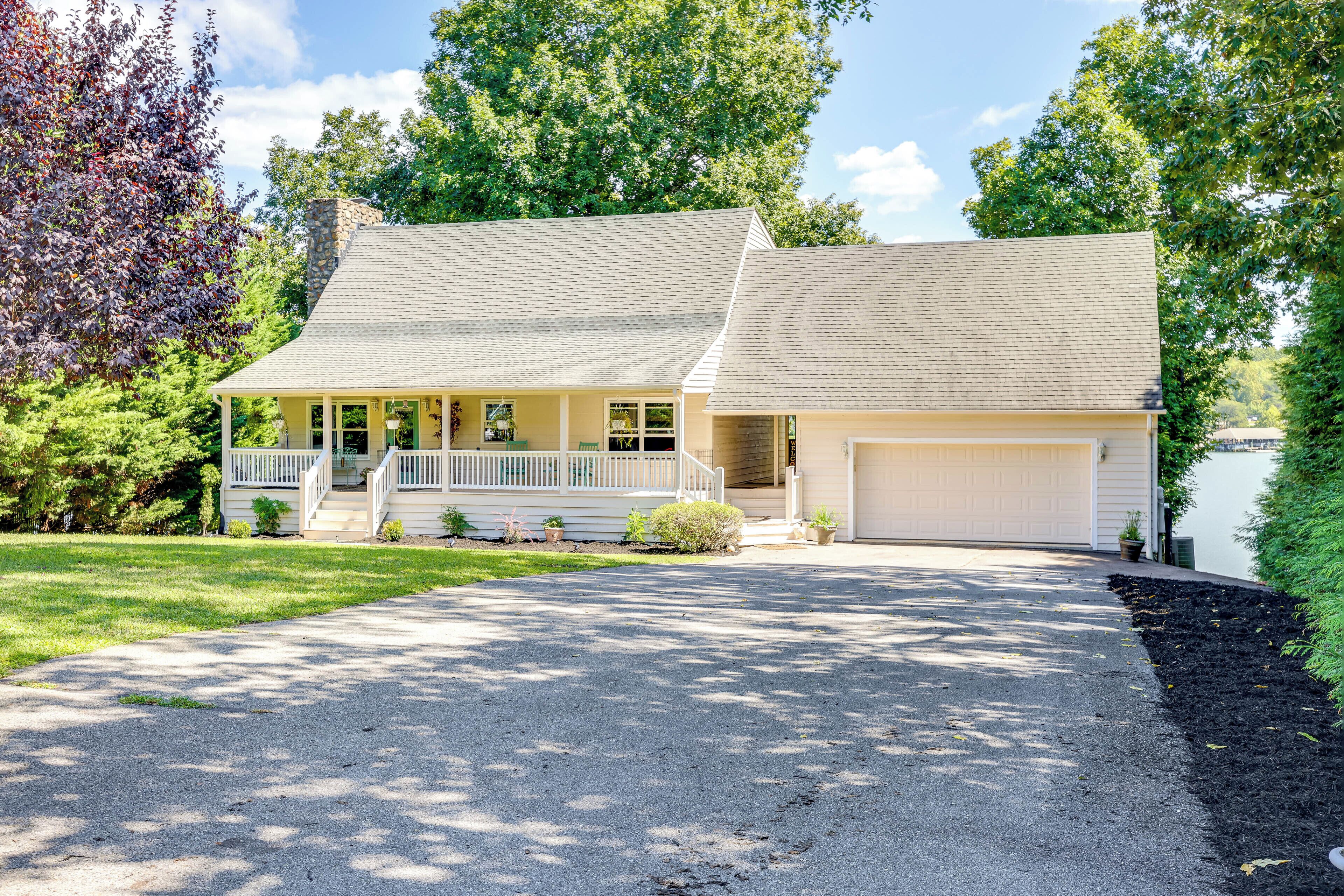 A two-story house with a front porch, a garage, and a driveway.