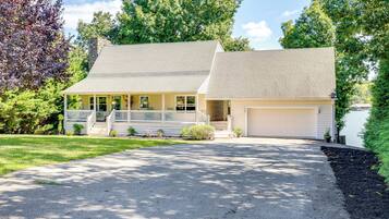 A two-story house with a front porch, a garage, and a driveway.