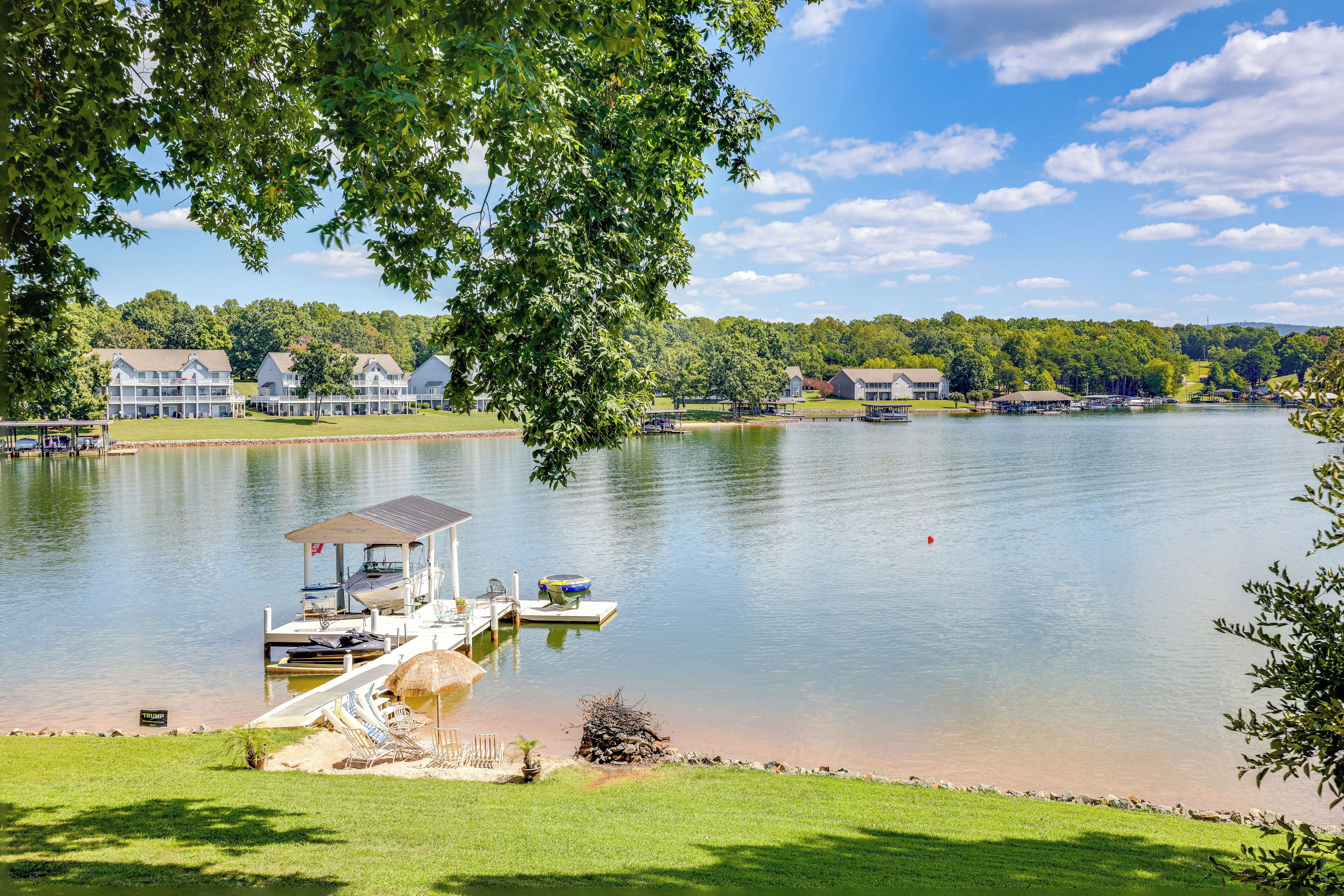 Une propriété au bord du lac, dotée d’un quai, de bateaux et d’une zone herbeuse.