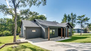 A modern single-story house with a covered porch, a garage, and a well-maintained lawn. - 1 Mi to Boating & Beaches: Lake Texoma Getaway (Pottsboro)