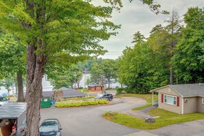 A residential area with a small house, a parked car, and a green dumpster. - Laconia Home w/ Beach - 1/2 Mi to Weirs Beach (Laconia)