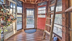 A wooden cabin interior with a door, windows, and a wooden ladder. - Strawberry Plains Cabin: Private Pond & Game Room! (Kodak)