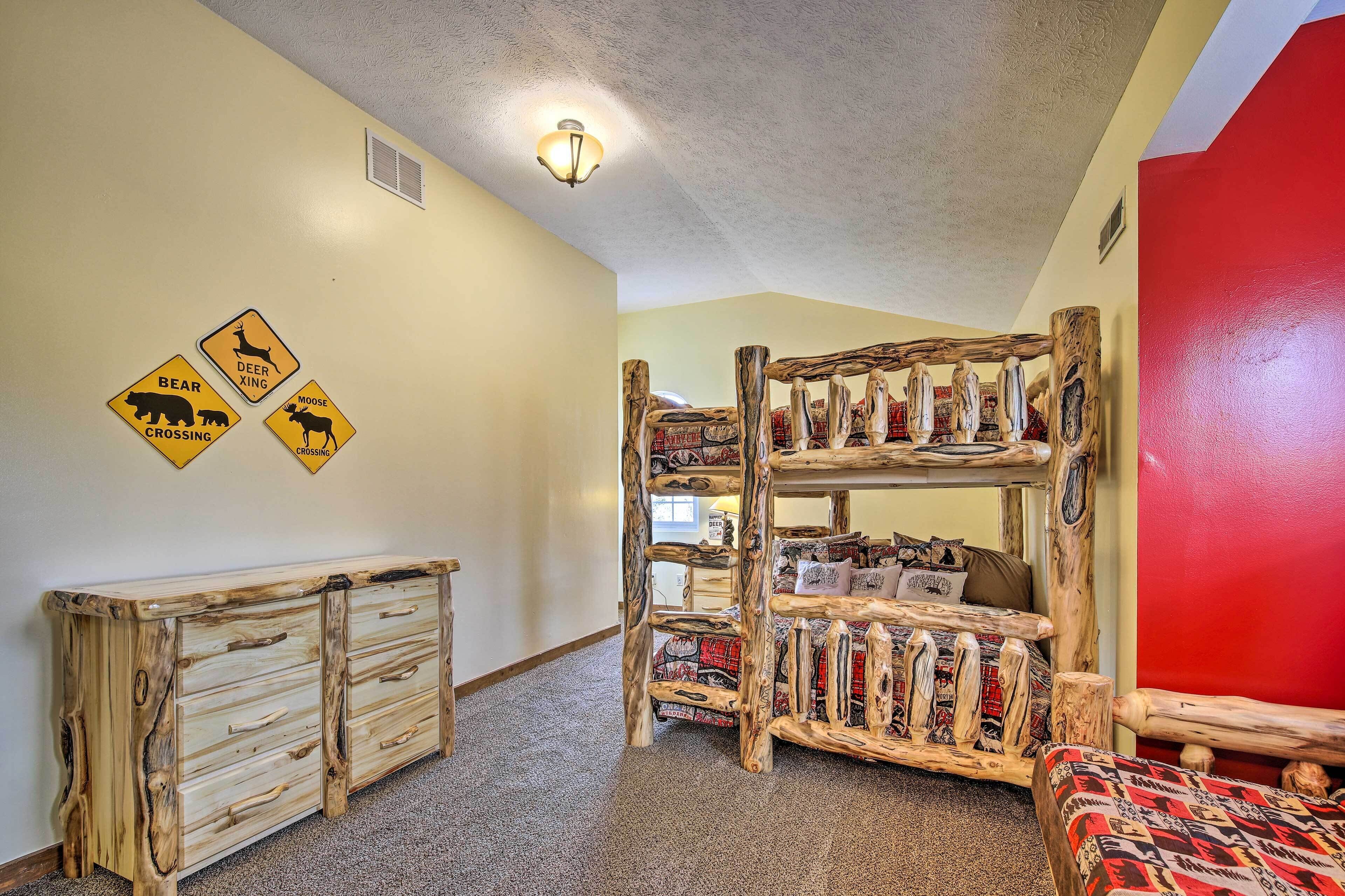 A bunk bed with a rustic design, a wooden dresser, and animal crossing signs on the wall.