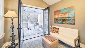An open glass door leading to a balcony with a white bench and a colorful fish mural on the wall. - Pittsburgh Home: Walkable Location! (Pittsburgh)