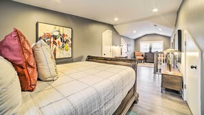 A bedroom with a large bed, a desk, a chair, and a painting on the wall. - Pittsburgh Home: Walkable Location! (Pittsburgh)