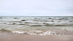 A beach with waves approaching the shore. - 5 Mi to Point Beach State Forest: Home w/ Fire Pit (Two Rivers)
