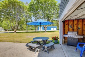 A patio with a table and benches, a blue umbrella, and a barbecue grill. - 5 Mi to Point Beach State Forest: Home w/ Fire Pit (Two Rivers)