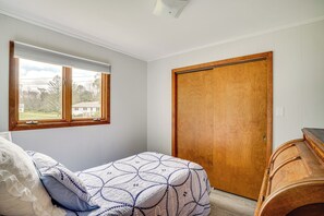 A bedroom with a bed, a window, and a wooden door. - 5 Mi to Point Beach State Forest: Home w/ Fire Pit (Two Rivers)