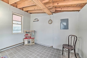 A room with a wooden ceiling, a small kitchenette, a clock, and a chair. - Walkable St Ignace Condo w/ Lake Huron Views (St Ignace)