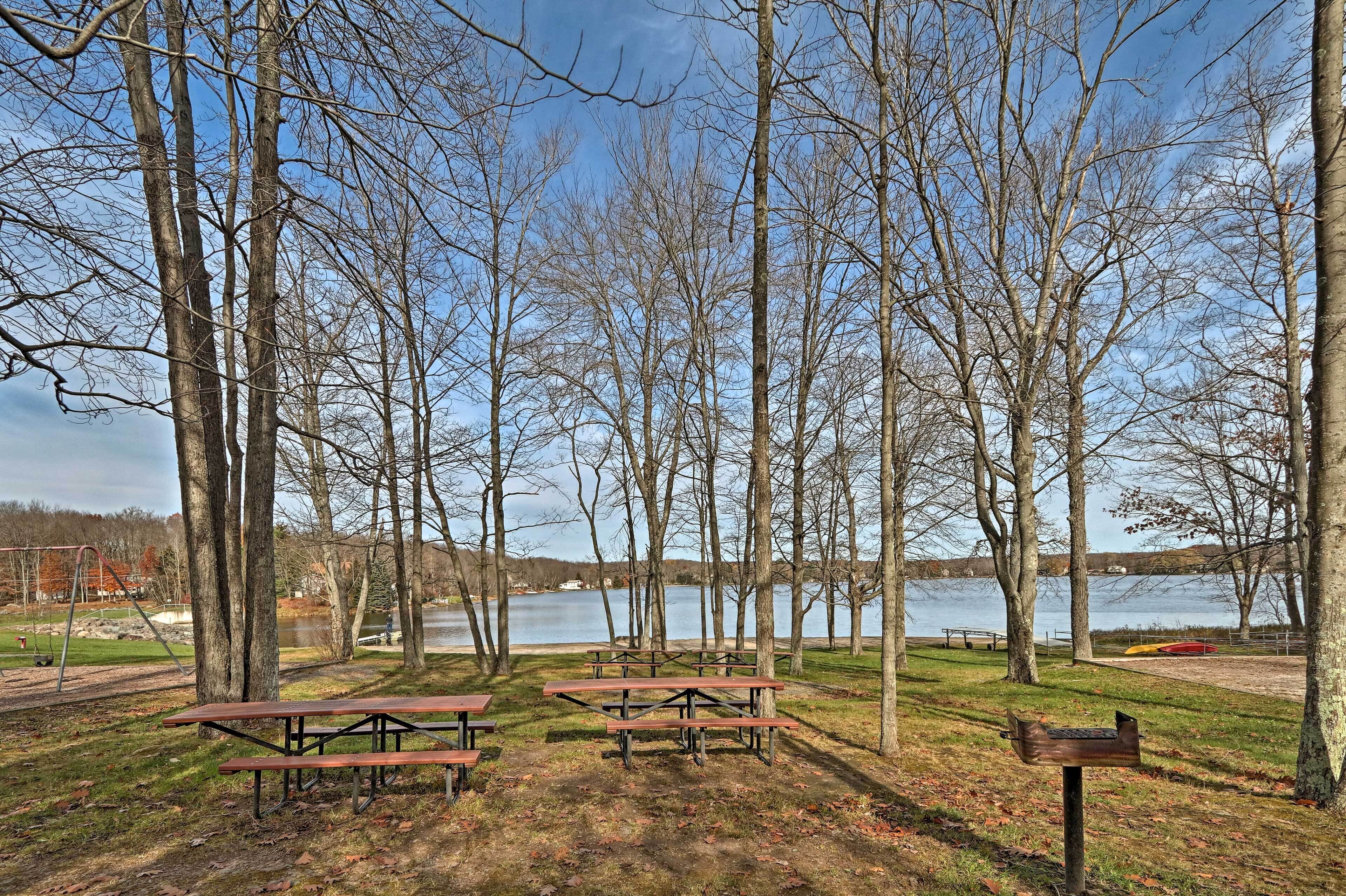A park with picnic tables and a lake in the background.