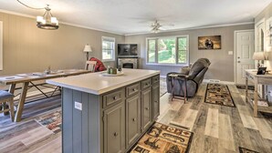 A spacious living area with a large island, a fireplace, and a ceiling fan.