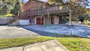 A two-story building with a balcony, a red door, and a staircase leading to the upper level.