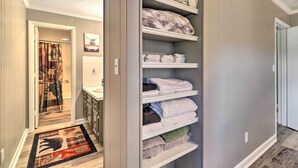 A walk-in closet with shelves for folded towels and blankets.