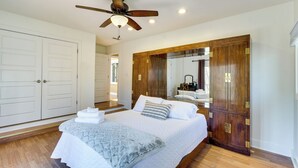 A bedroom with a large bed, a ceiling fan, wooden wardrobe, and a mirror. - Spacious Prospect Cottage w/ Deck & Scenic Views (Prospect)