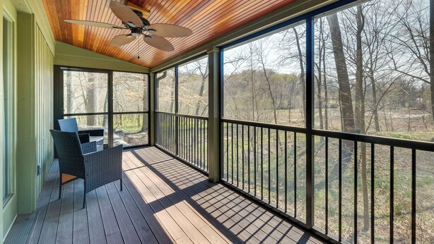 A covered porch with a ceiling fan, large windows, and a view of trees. - Spacious Prospect Cottage w/ Deck & Scenic Views (Prospect)
