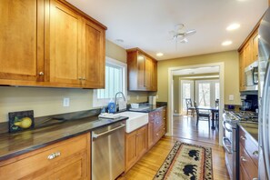 A kitchen with wooden cabinets, stainless steel appliances, and a large window. - Spacious Prospect Cottage w/ Deck & Scenic Views (Prospect)
