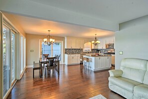 A spacious kitchen with a central island, white cabinetry, and a dining area with a table and chairs. - Waterfront House W/dock & Deck on Little Bear Lake (Johannesburg)