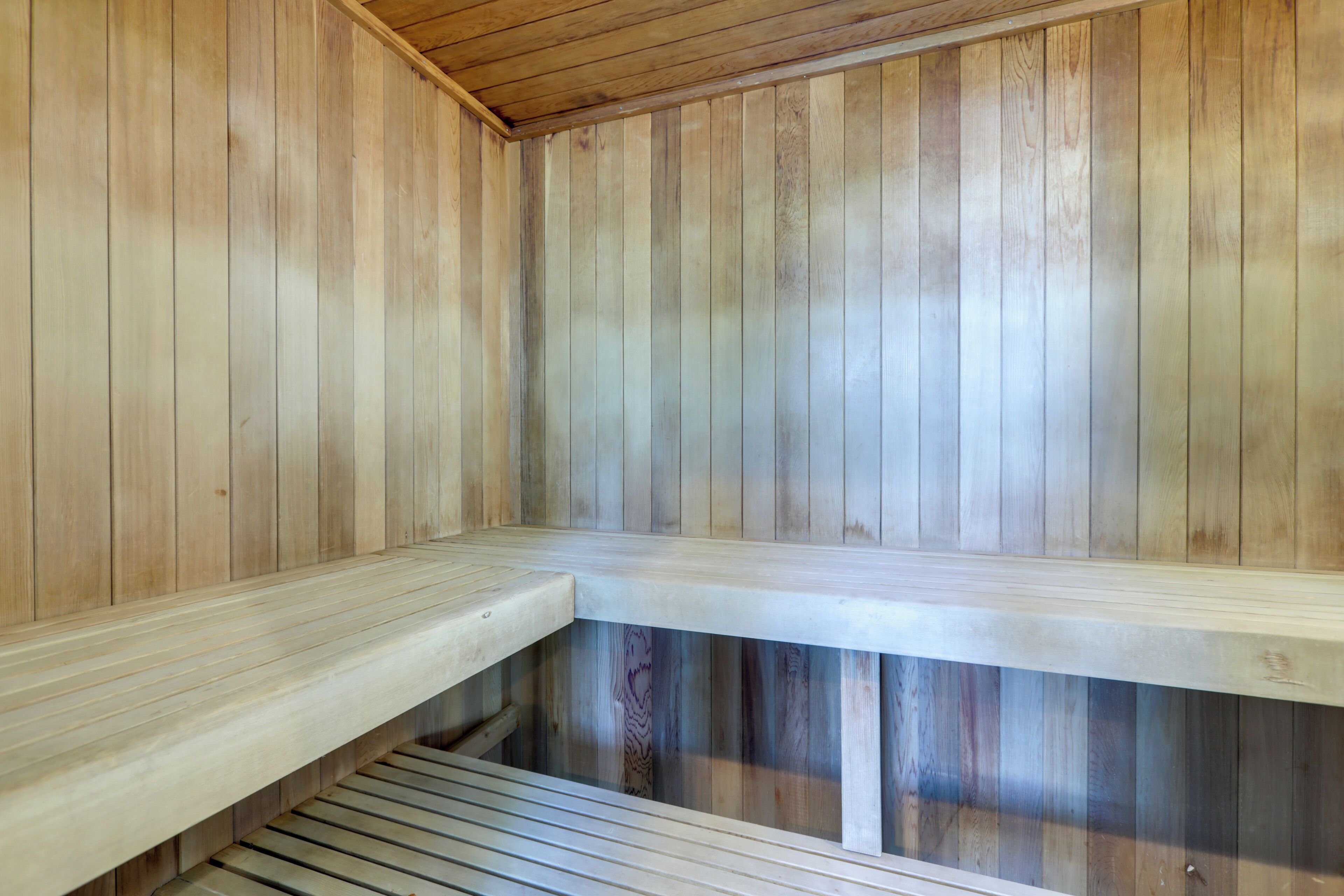 Un sauna avec des murs et des bancs en bois.