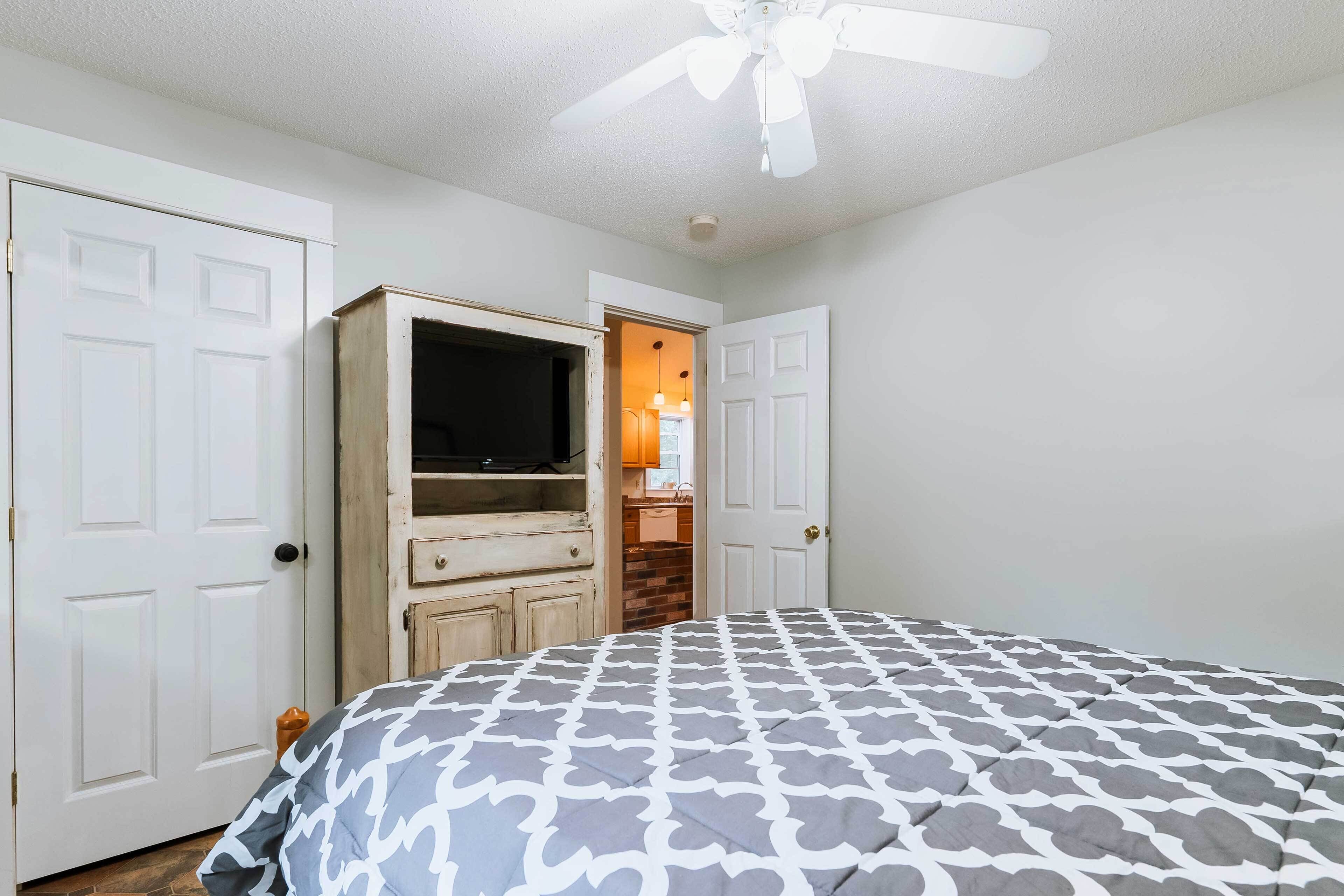 A bedroom with a bed, a wardrobe, and a television.