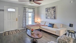 A living room with a sectional sofa, a round coffee table, a ceiling fan, and a motivational wall art piece. - Updated Baton Rouge Home w/ Grill ~ 10 Mi to Dtwn! (Baton Rouge)