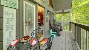 A wooden deck with outdoor furniture, including chairs and a table.