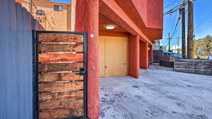 A building with a red exterior, a wooden gate, and a concrete ground. - Oxnard Apartment < 1/2 Mi to Beaches! (Oxnard)