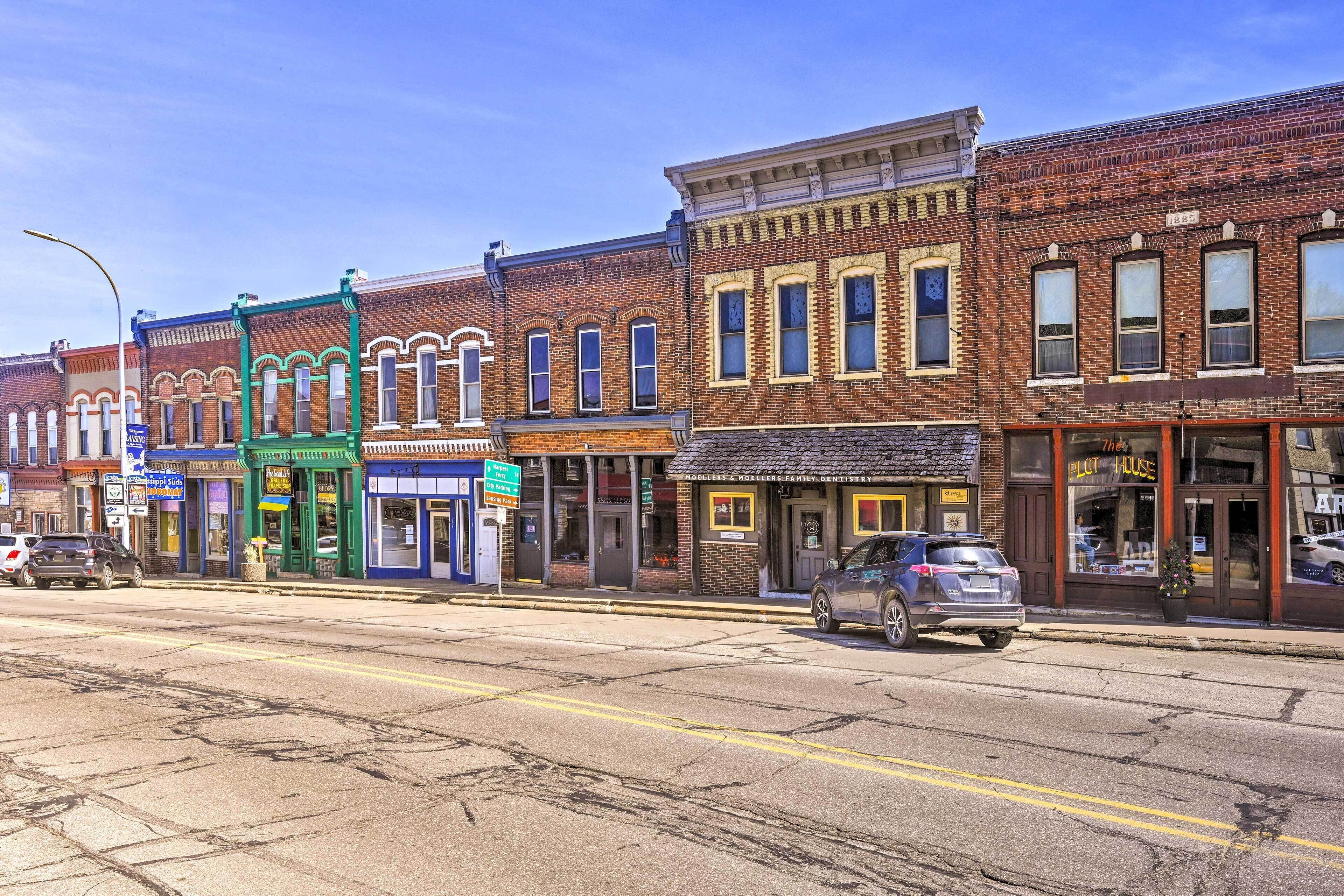 A street view with a row of brick buildings, including a dental office and a store with a green awning.